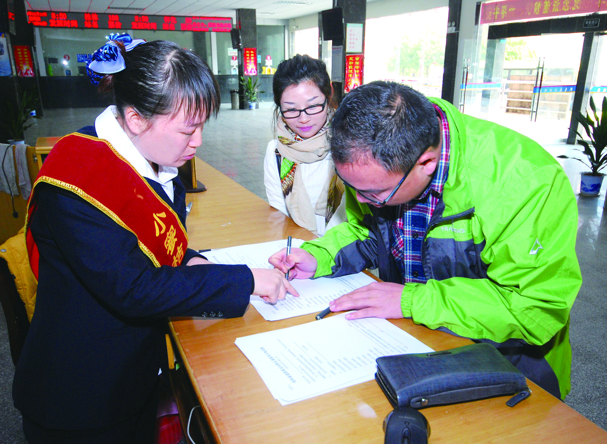 圖為洞口汽車總站站務(wù)人員在熱心為旅客服務(wù)。